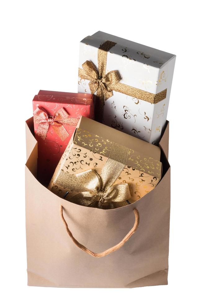 Gift boxes in brown paper bag on white background. photo