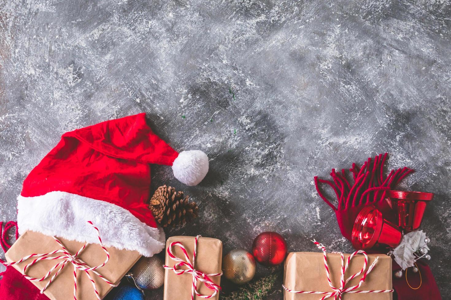 Top view of gift packages wrapped in brown paper with christmas decoration on gray grunge background. Free space for text photo