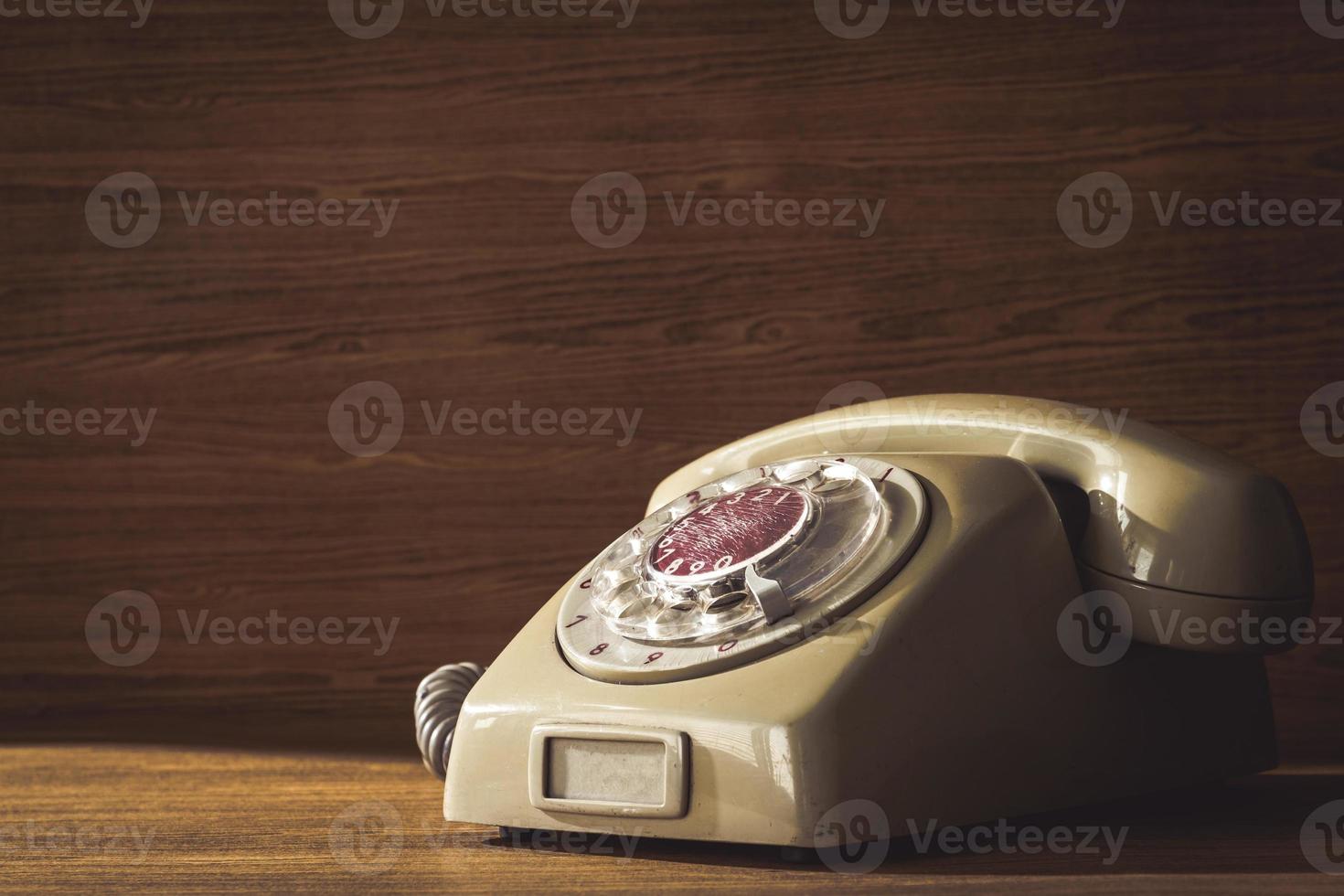 Old telephone on wooden table background. photo