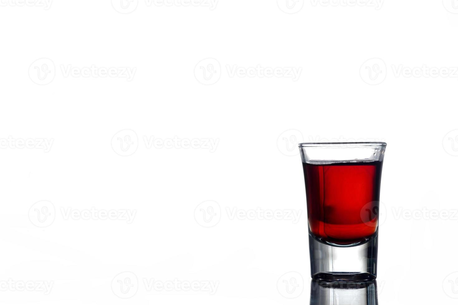 Glass of alcohol on a white background. Free space for text photo