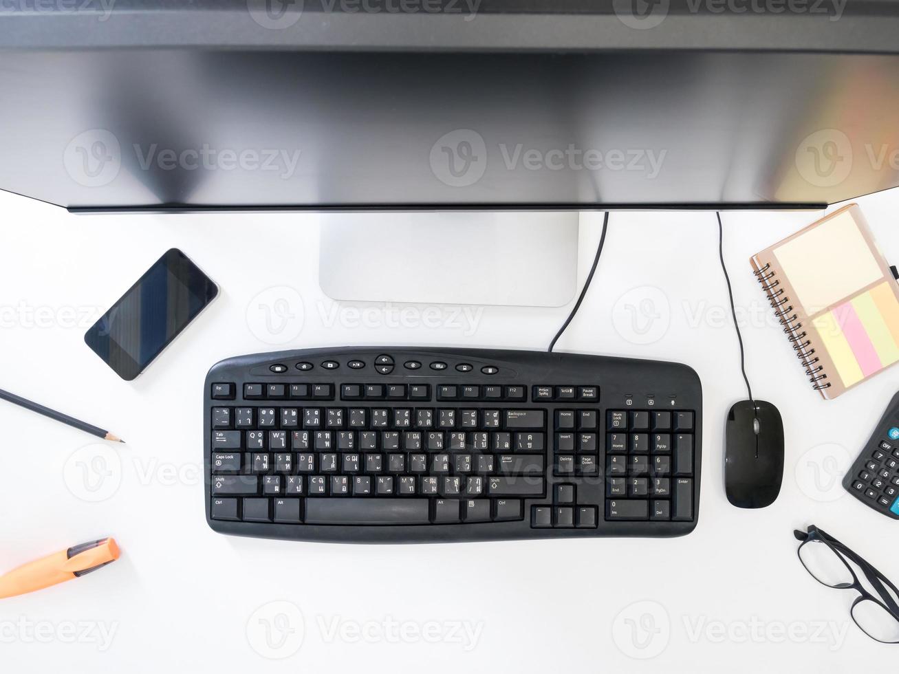 vista superior de la computadora de escritorio con suministros de oficina sobre fondo blanco. foto