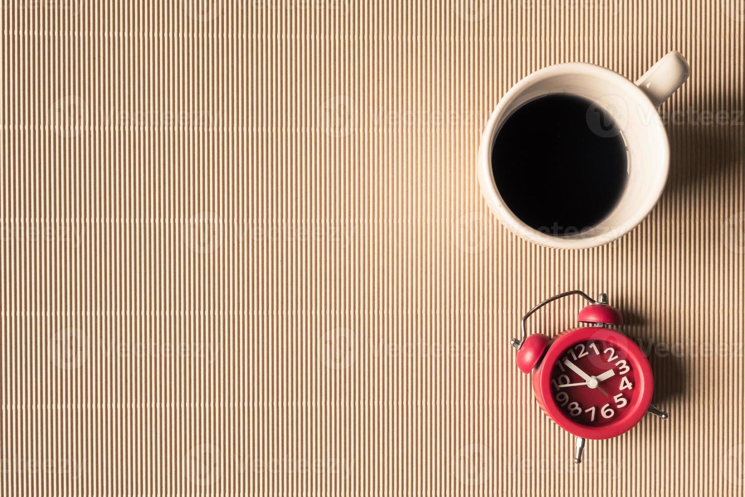Top view of coffee cup with clock on table. Free space for text photo