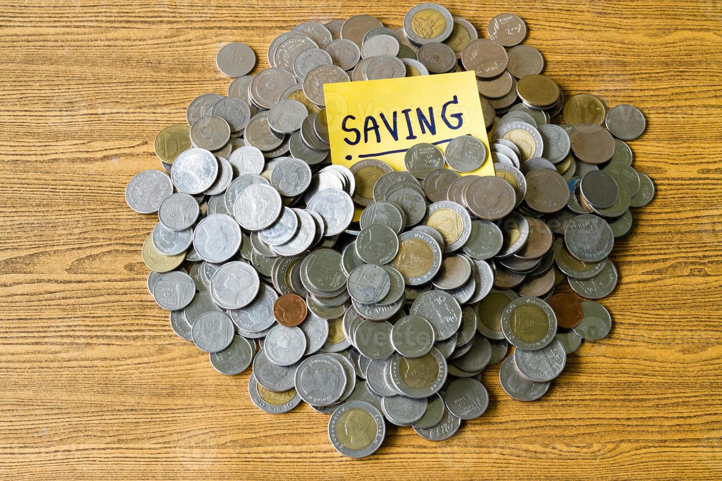 Pile of coins with saving label on a wooden table. Financial Concept. photo