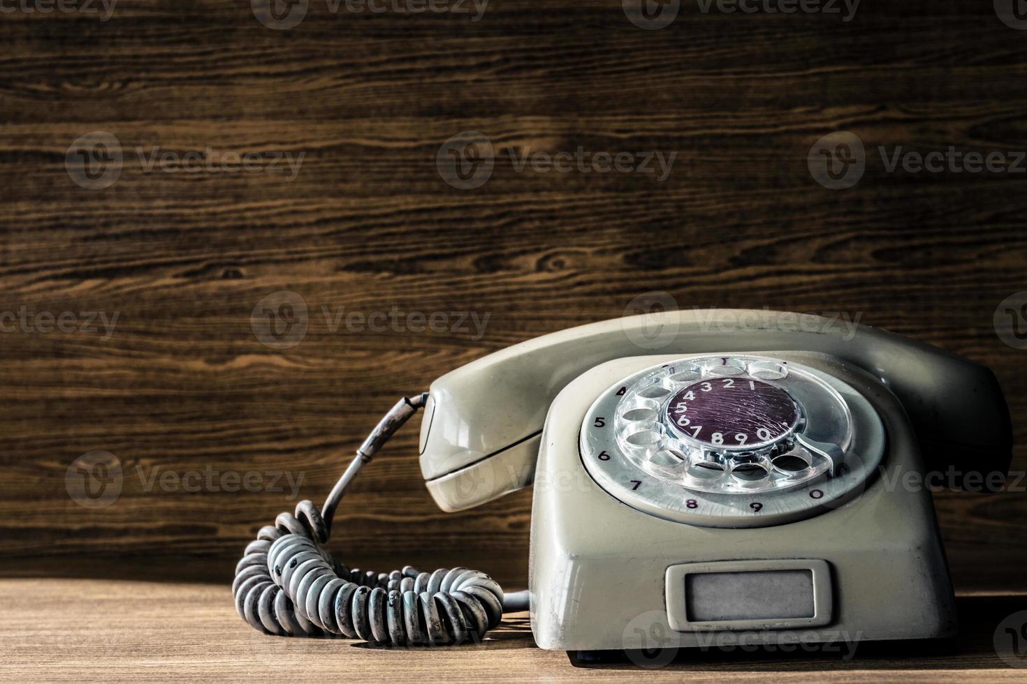 Old telephone on wooden table background. photo