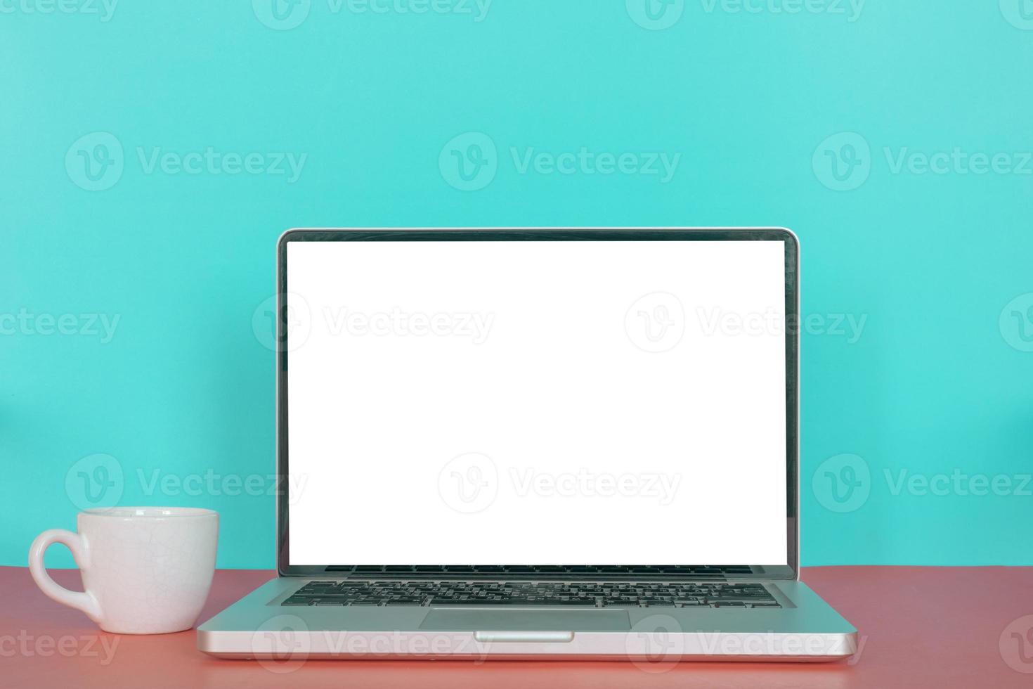 Modern laptop with blank screen, coffee cup on pastel color background. photo