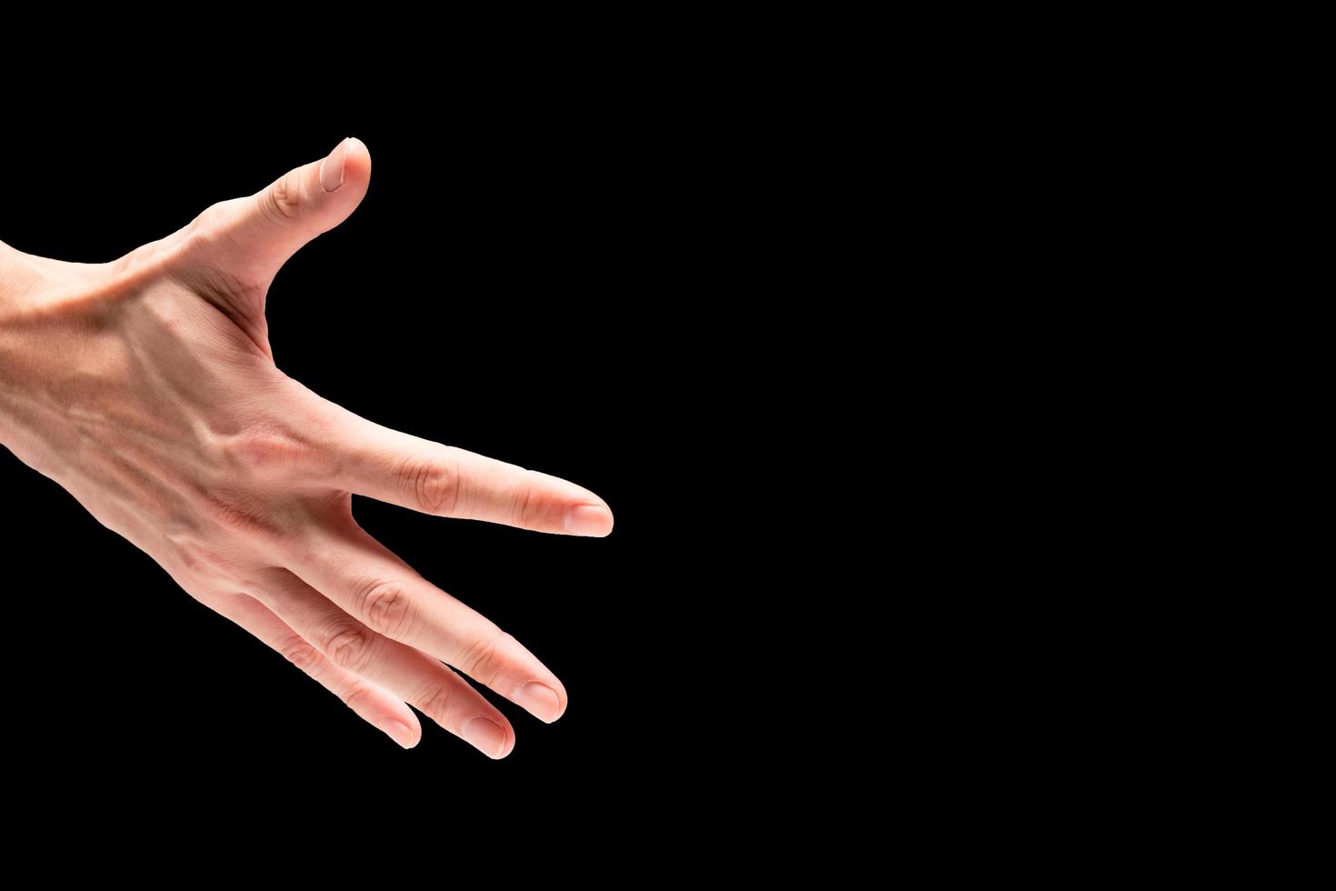 Male hand on a black background. Free space for text photo