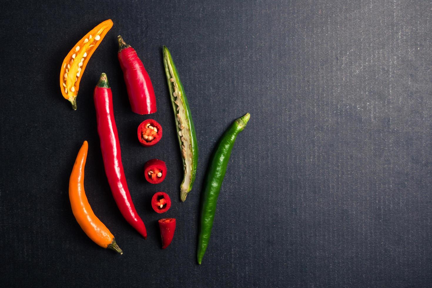 Colorful mix of chili pappers on black background. Free space for text photo