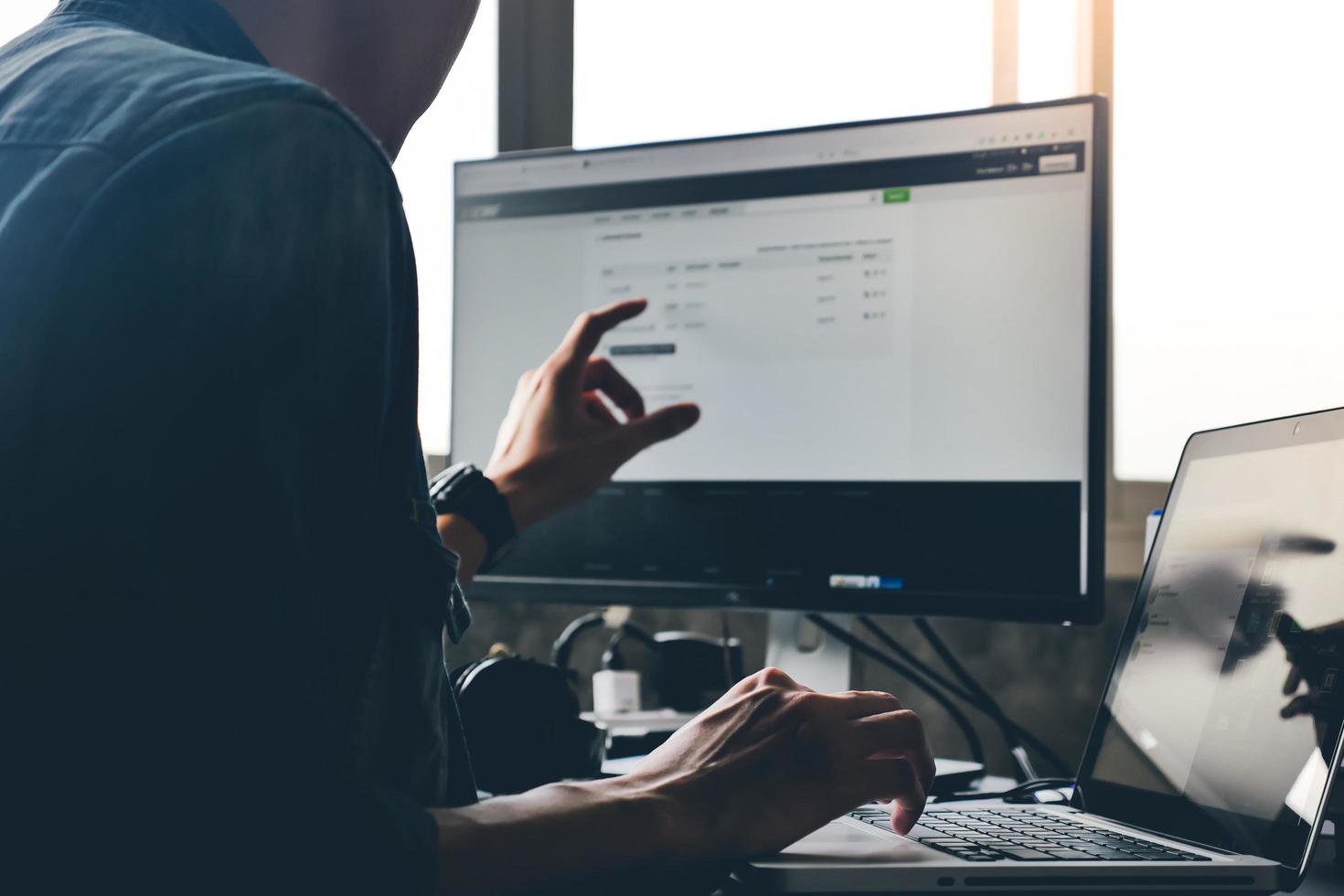 hombre casual que usa la computadora en el escritorio. foto