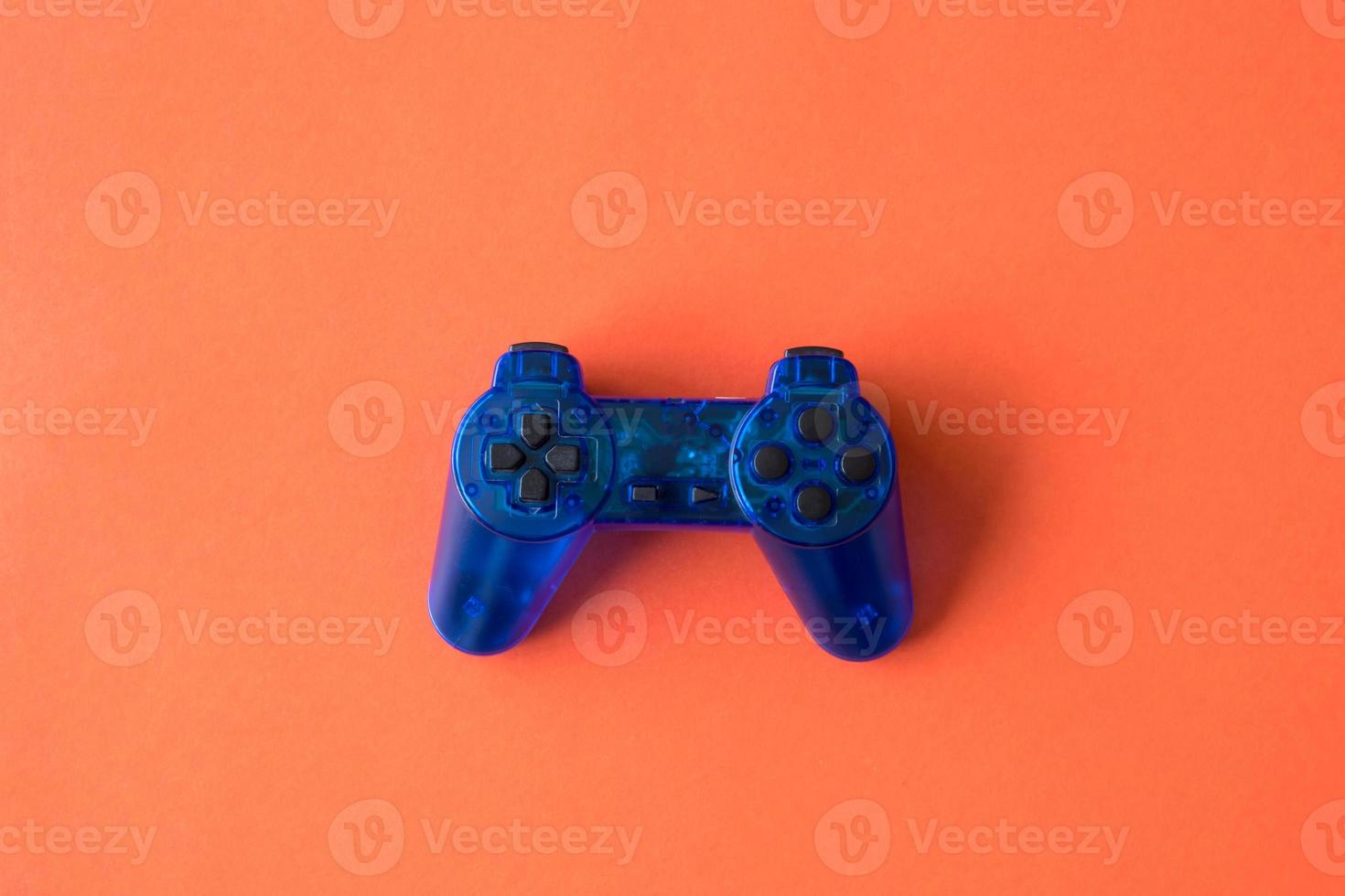 Video game controller on orange background. photo