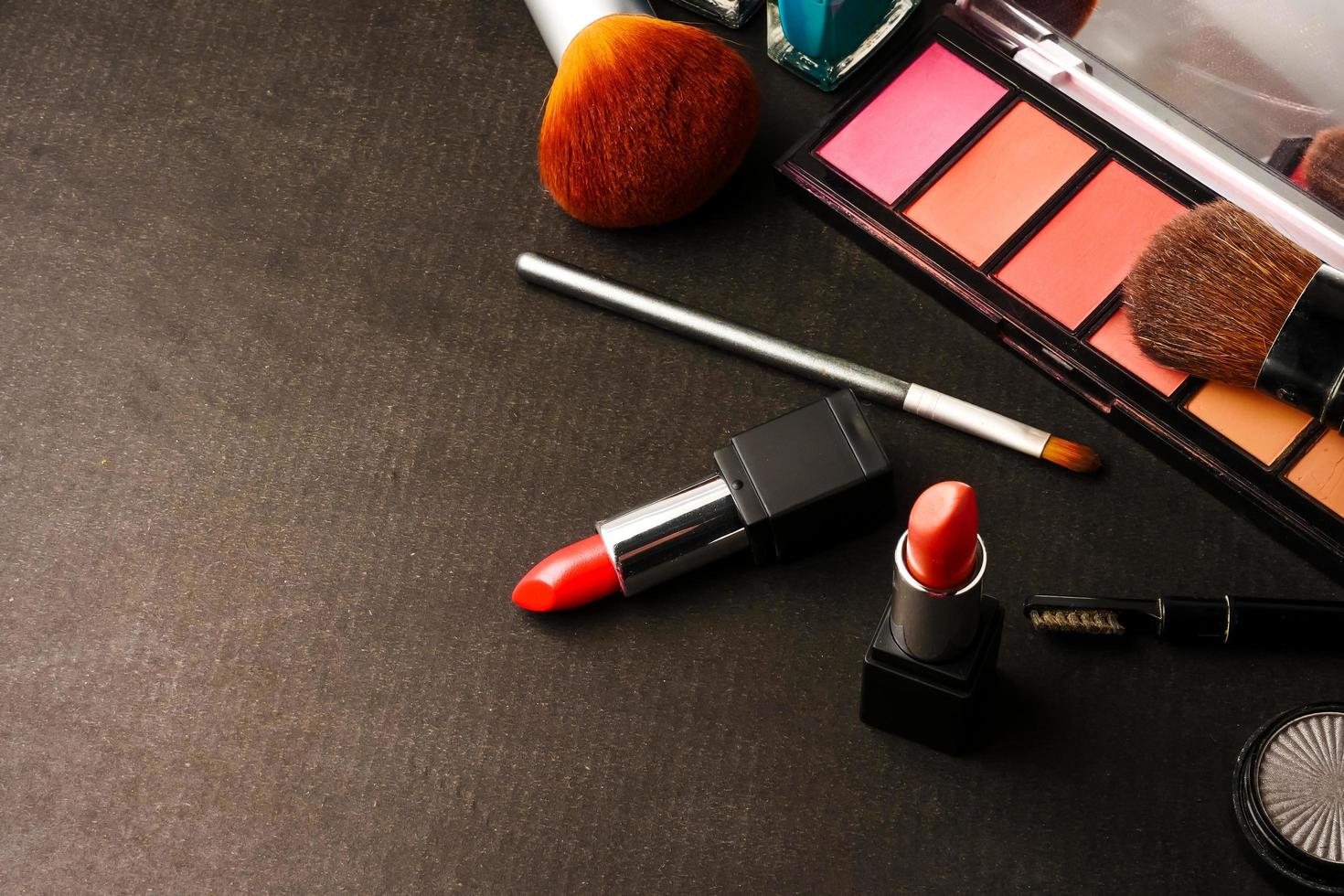 Top view of cosmetics set for makeup on a black background. Free space for text. photo