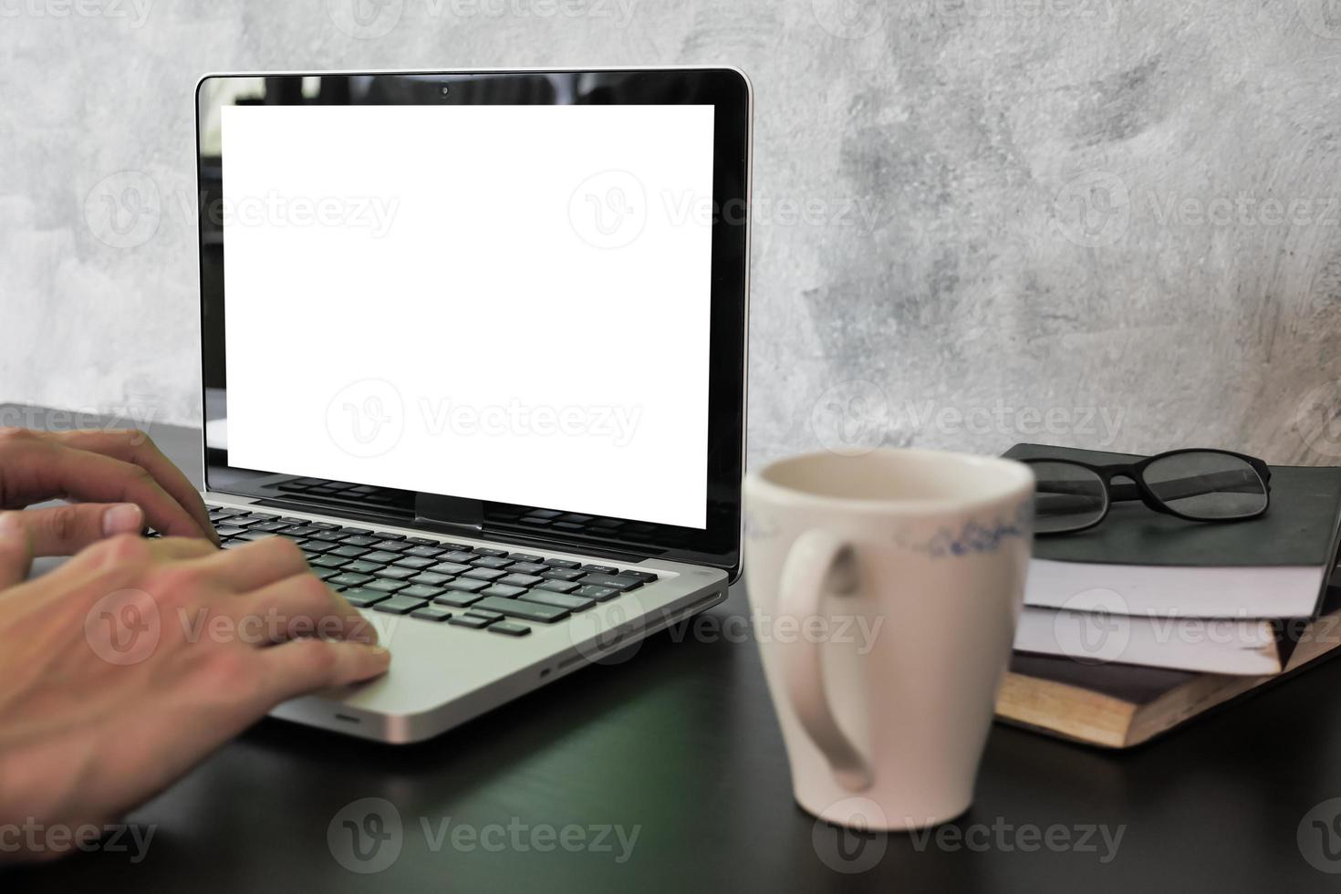 Close up of male hands using laptop with white screen monitor on the desk. photo