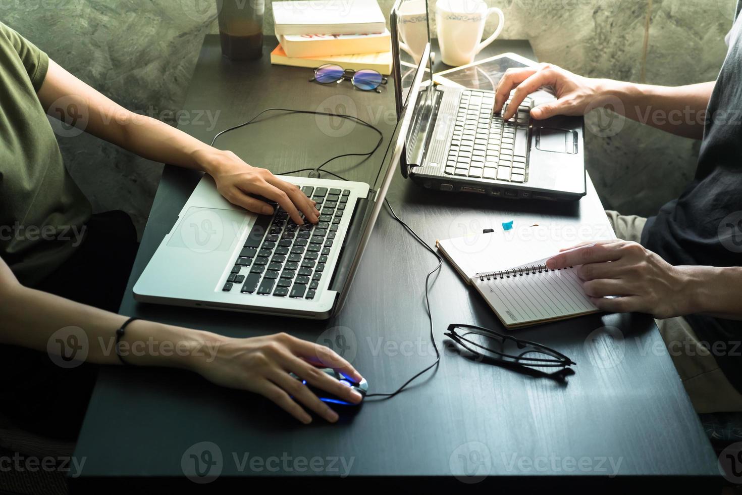 Coworkers working on the same desk, they are using a laptop, Start up business concept photo