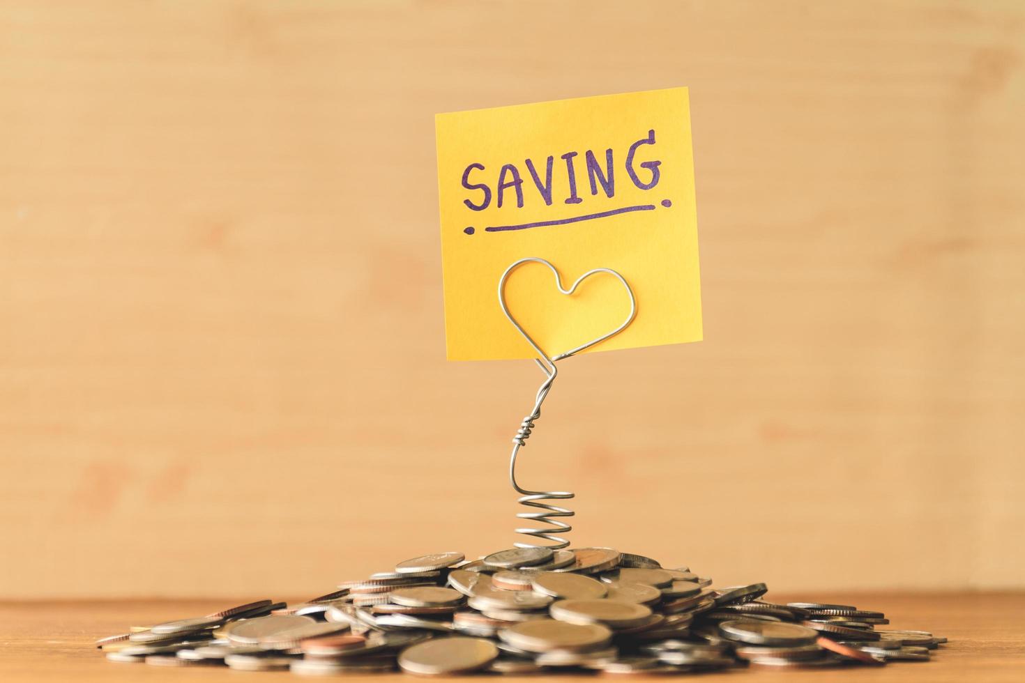 Pile of coins with saving label on a wooden table. Financial Concept. Selective focus. photo