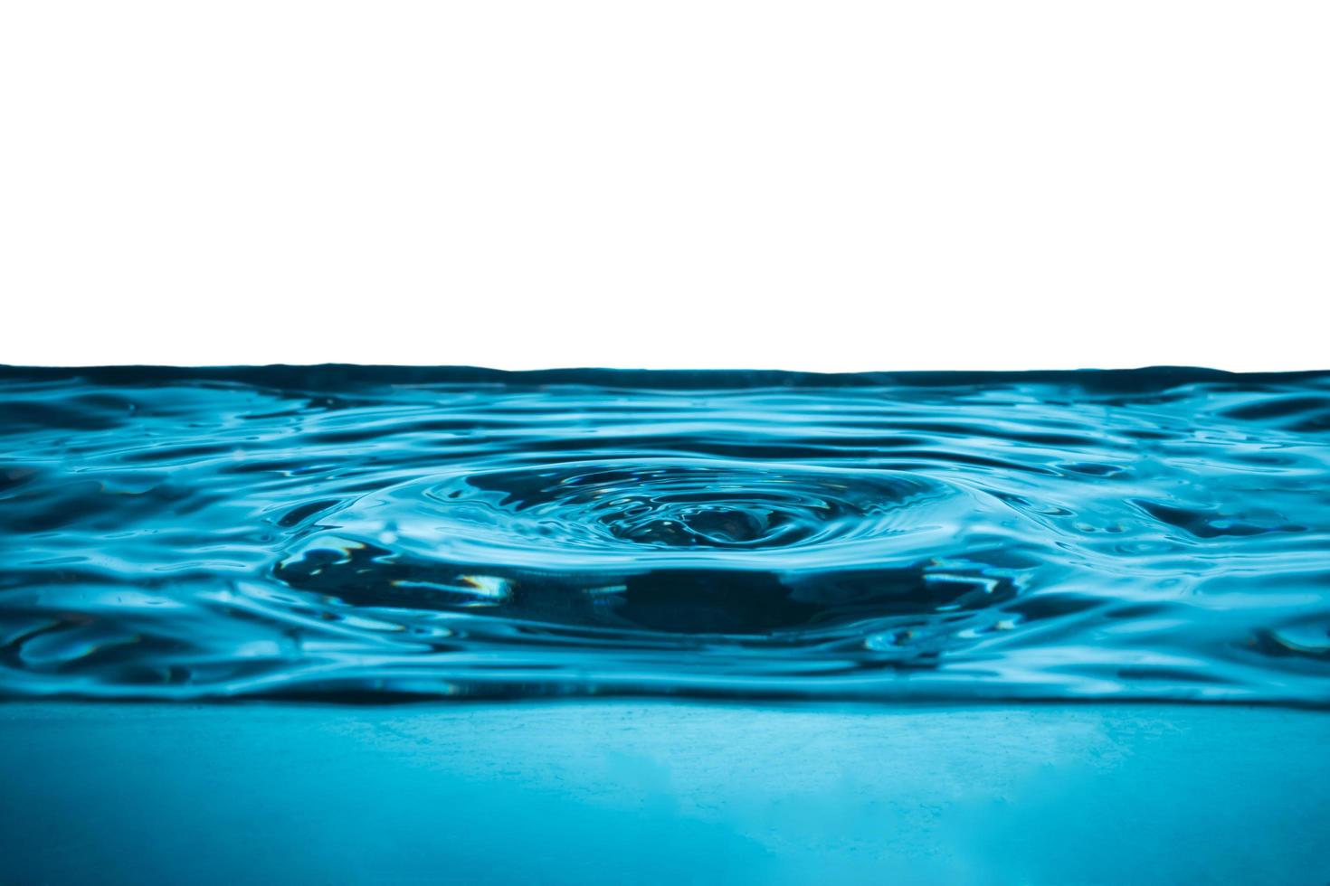 Water drop on water surface, Blue wave and bubbles background. photo