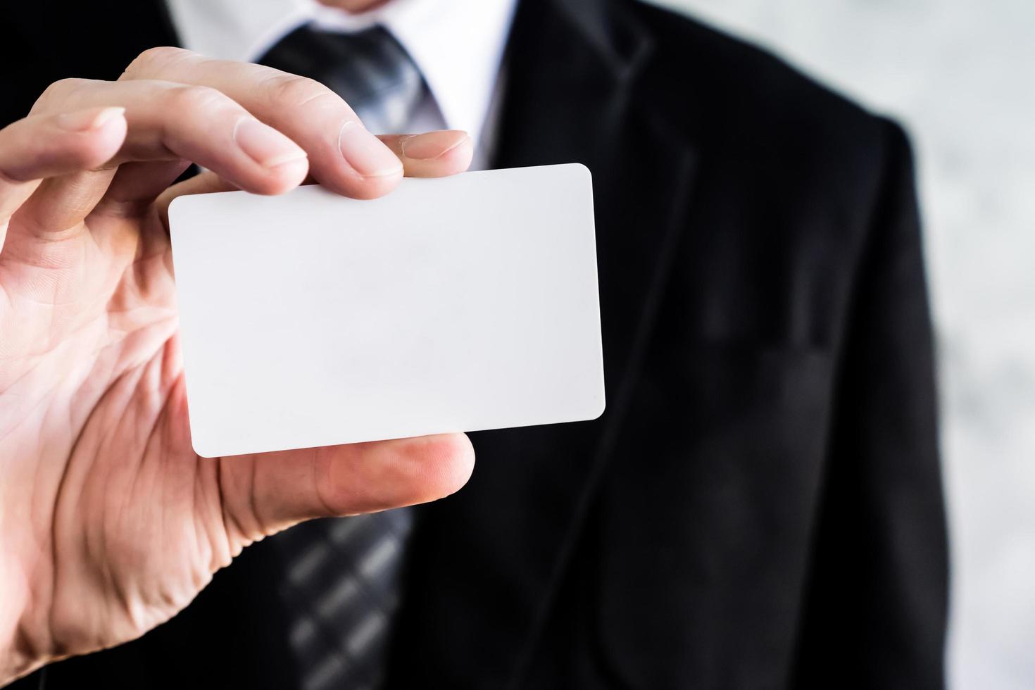 Close up of businessman holding white blank card. photo