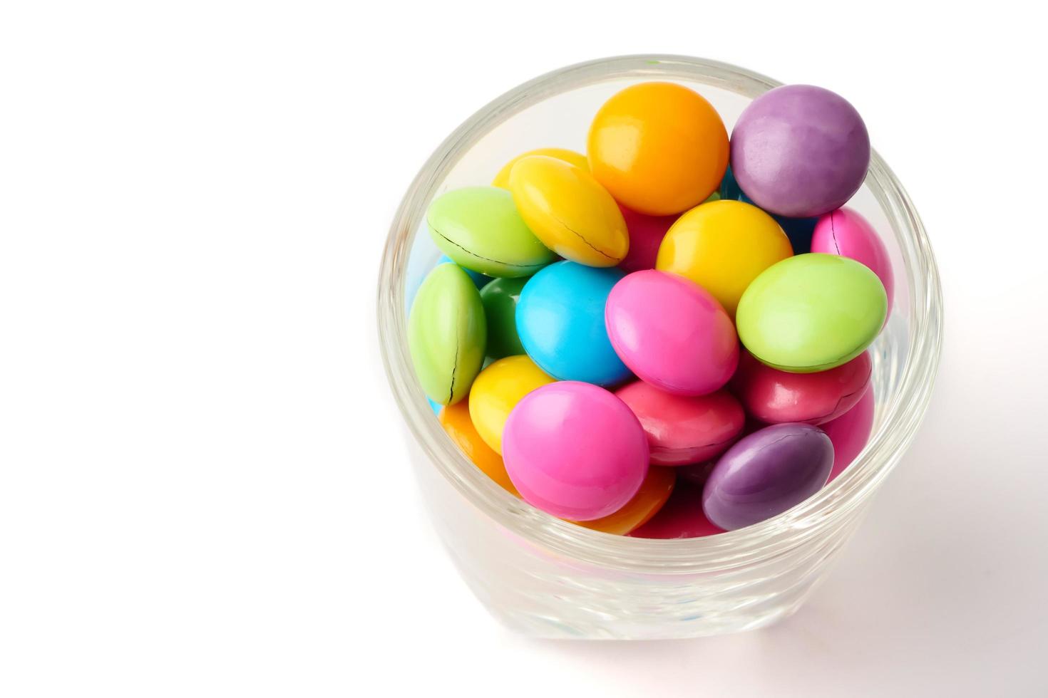 Colorful candies in glass on white background. photo