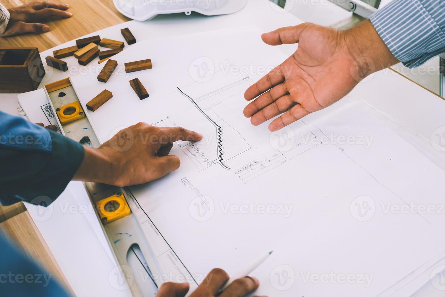 equipo de ingenieros discutiendo el boceto del plan de arquitectura en el sitio de construcción. foto