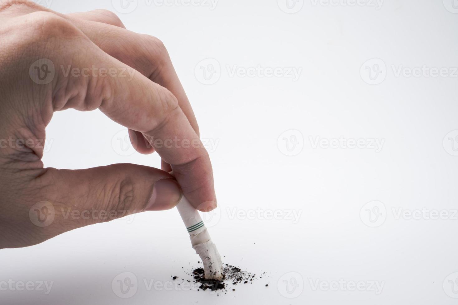 A hand push the cigarette stub on white background, Symbolic stop smoking concept, Free space for text photo
