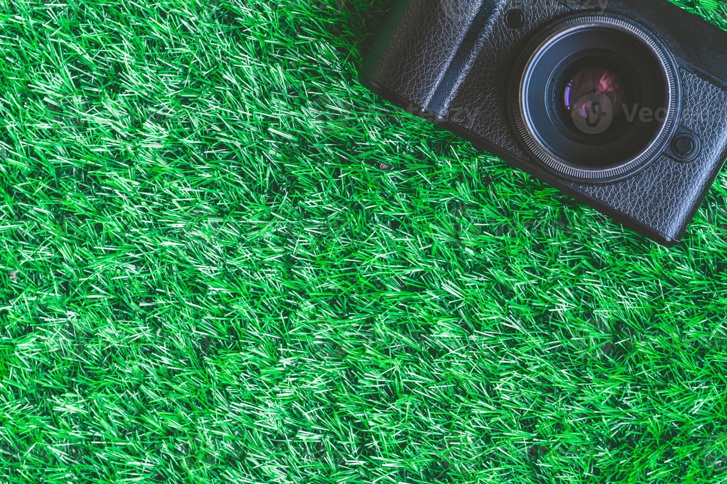 Camera on green grass background. Free space for text photo