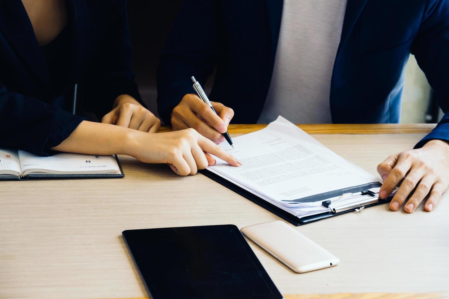 Businessman and businesswoman signing paper insurance, contract, important photo