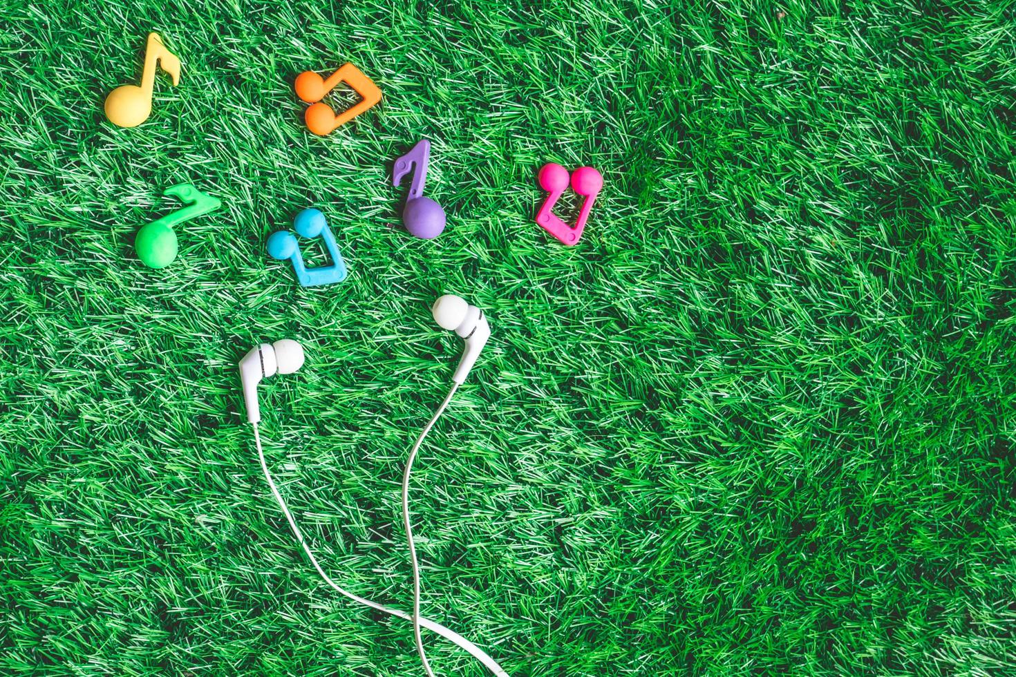 Top view of earphones on green grass background. photo