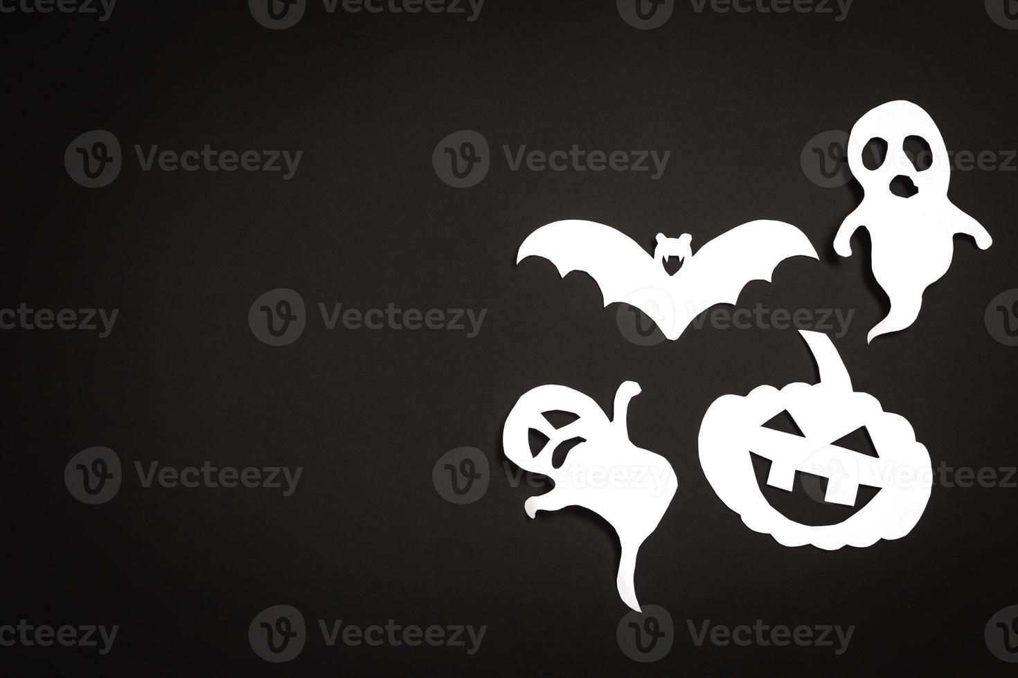 Halloween holiday background with pumpkin, ghosts and bat cut paper on black background. Free space for text. photo