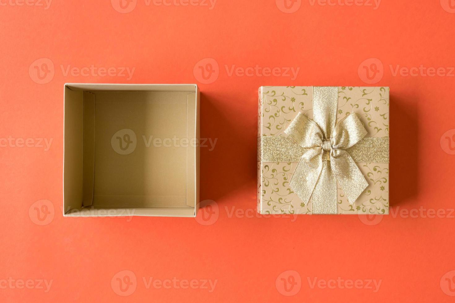 Top view of open gift box on orange background photo
