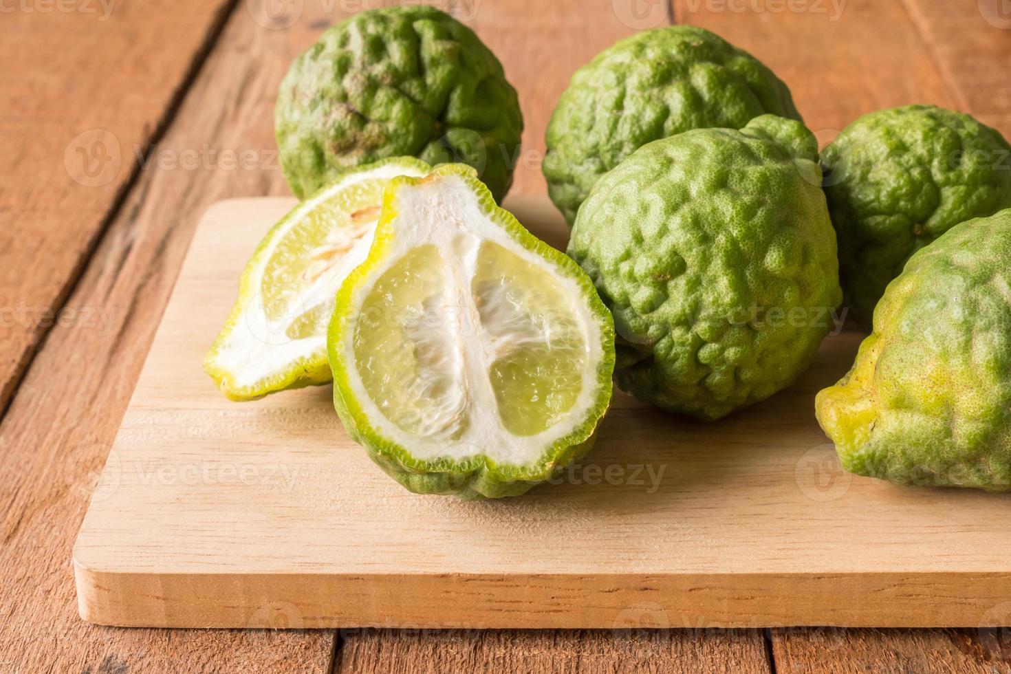 Close up of bergamot or kaffir lime on wooden table background. photo