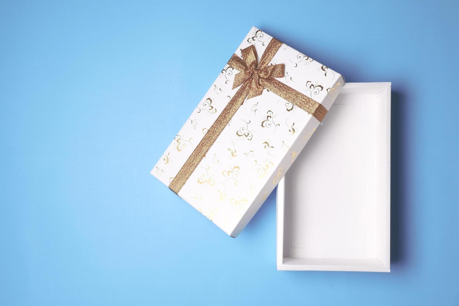 Top view of open white gift box on blue background. Free space for text photo