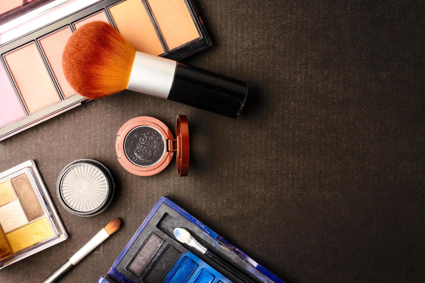 vista superior del conjunto de cosméticos para maquillaje sobre un fondo negro. espacio libre para texto. foto