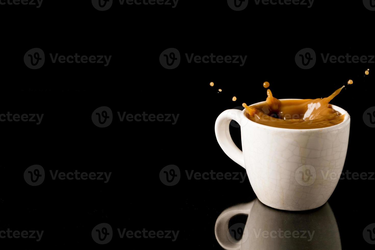 Cup of splashing coffee on black background. Free space for text photo