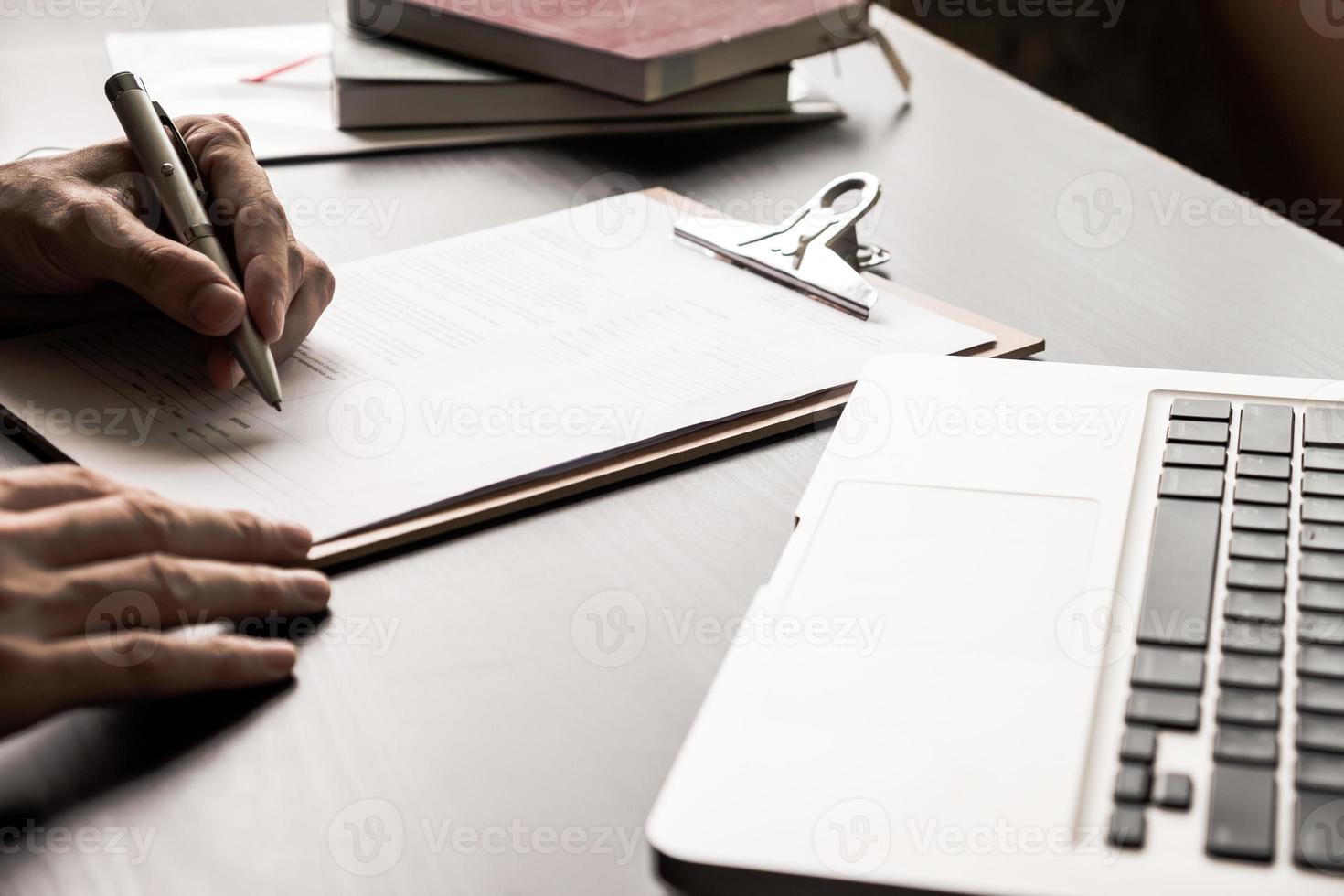 Close up of Businessman signing contract document on the office desk. photo