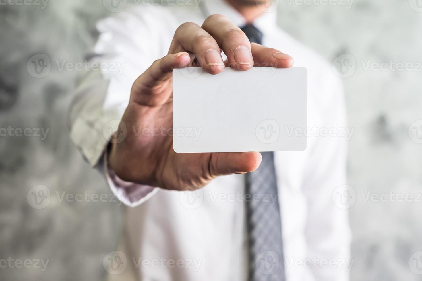 Close up of businessman holding white blank card on grunge background. photo