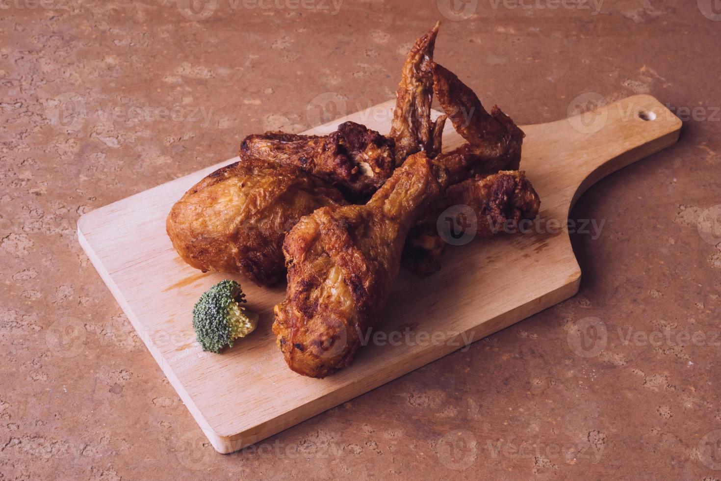 Fried chicken legs and wings on wooden tray. photo