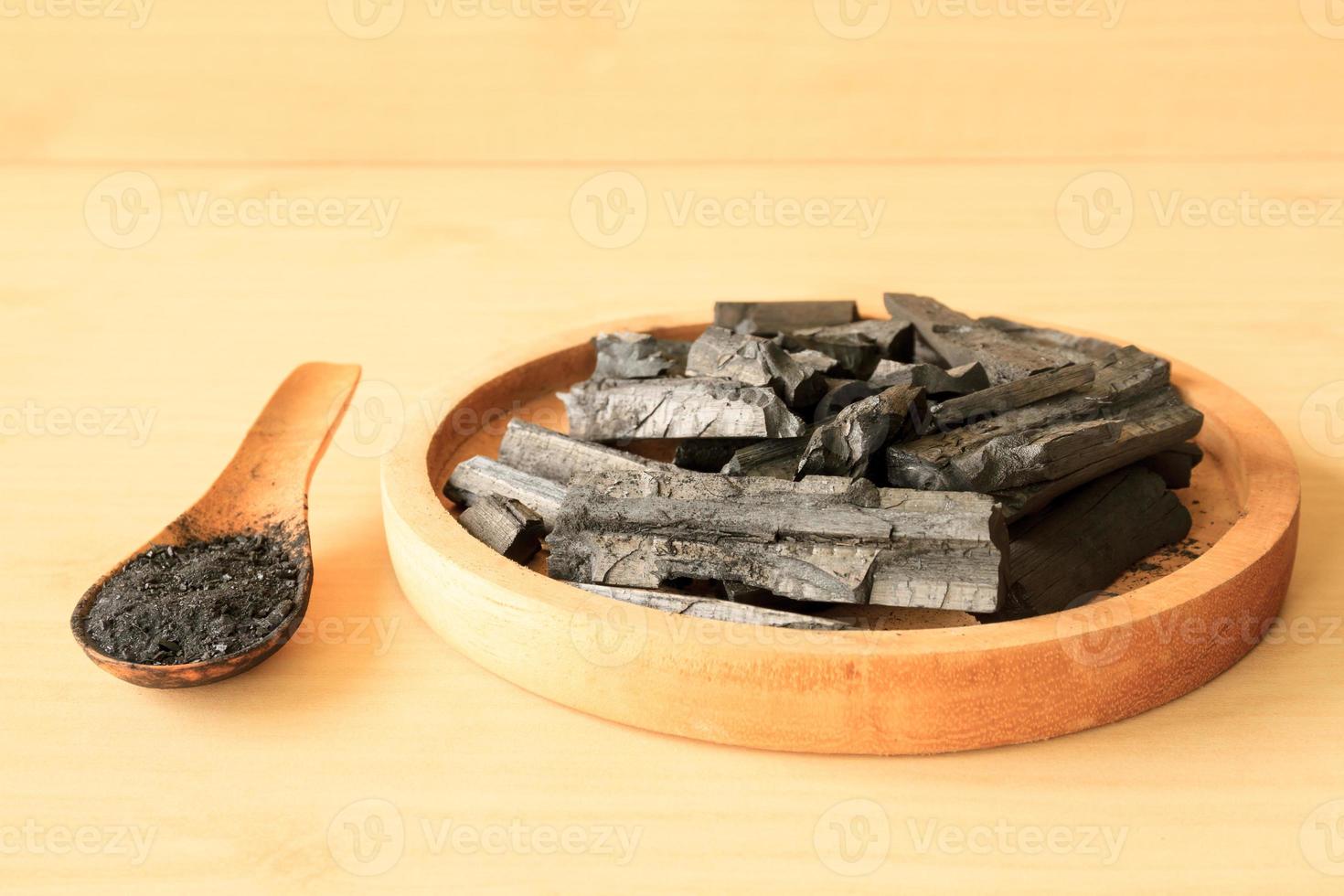 Charcoal and charcoal powder on wooden table background. photo