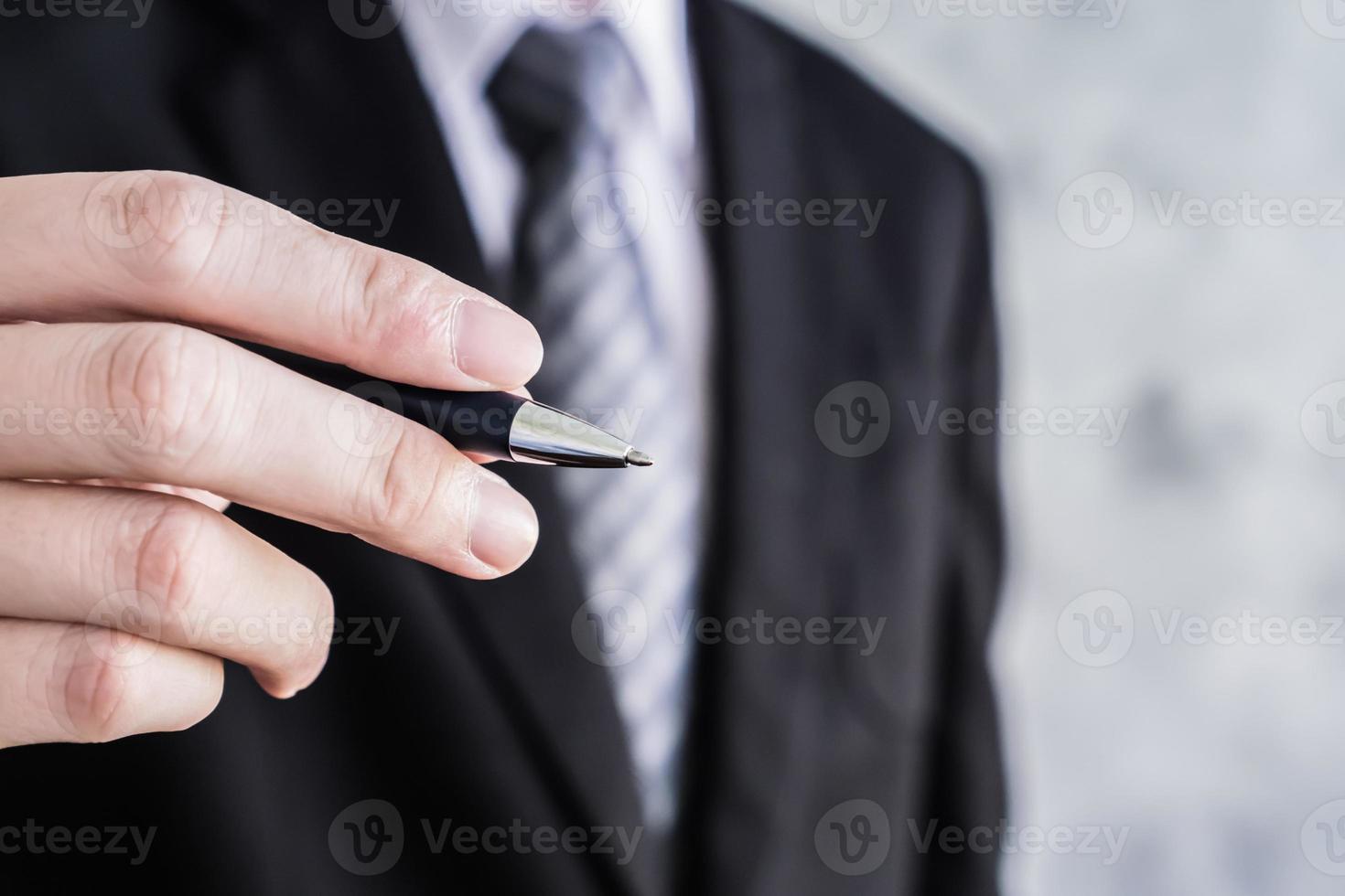 Close up of businessman hand holding pen on grunge background. photo