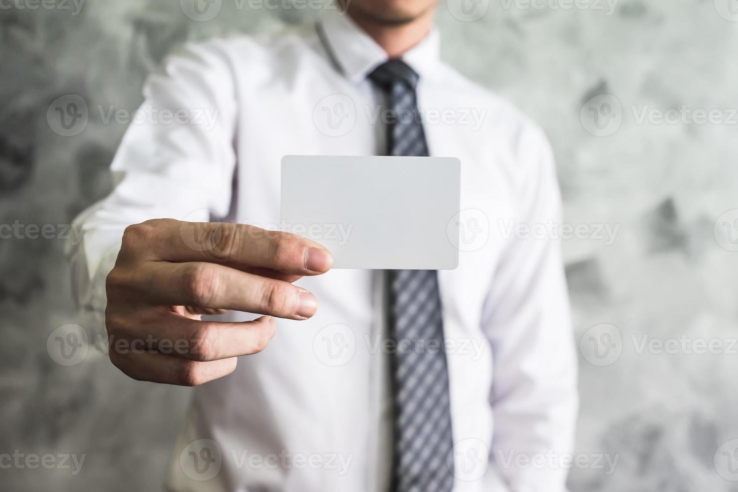 Close up of businessman holding white blank card on grunge background. photo