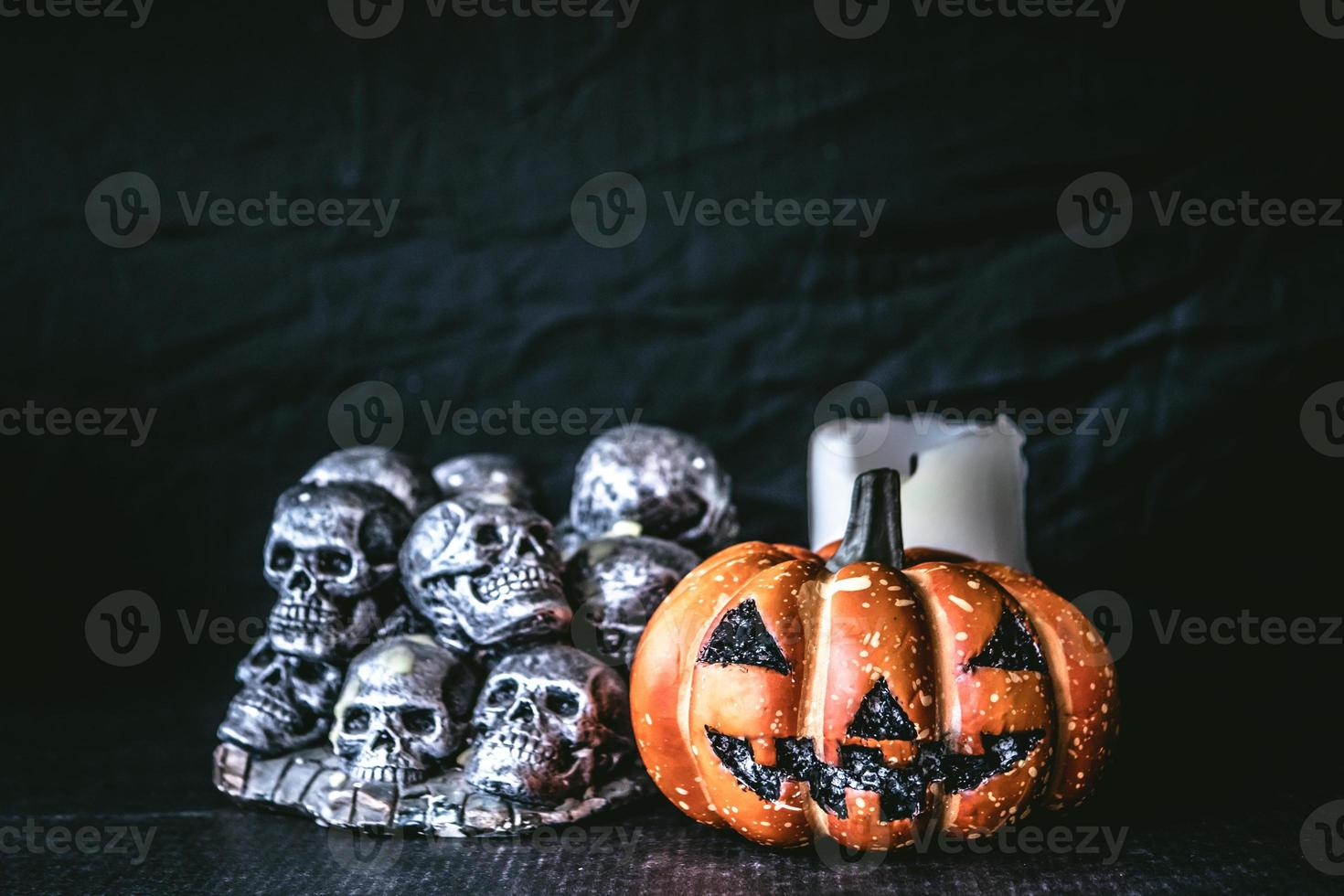 Halloween pumpkin with skulls and candle  on a black background. photo