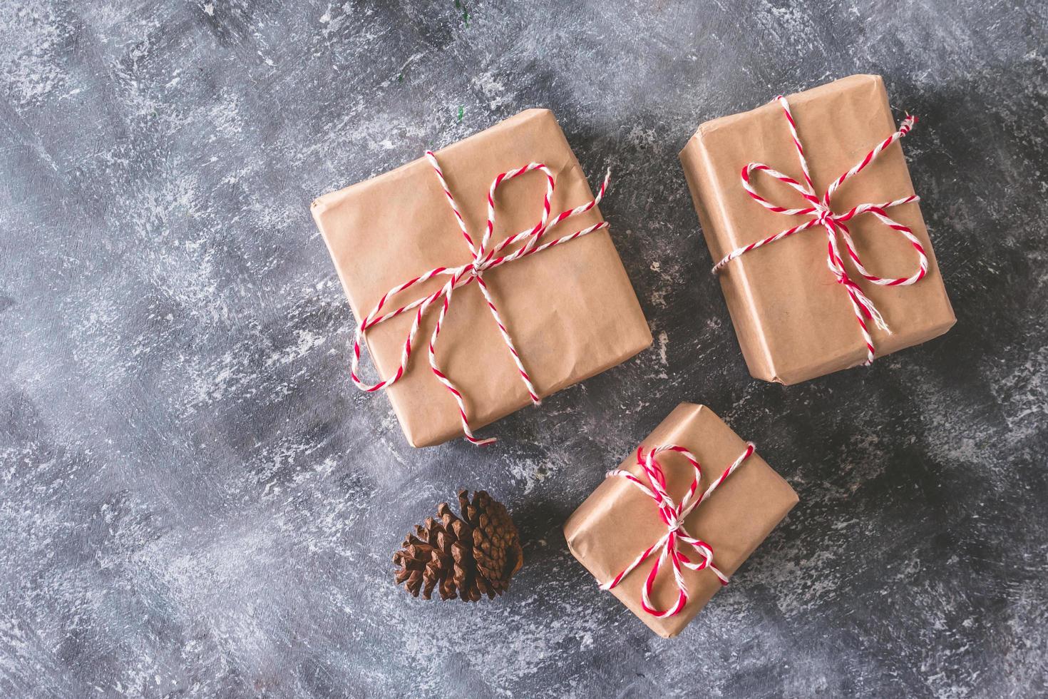 Top view of Gift packages wrapped in brown paper on gray grunge background. photo