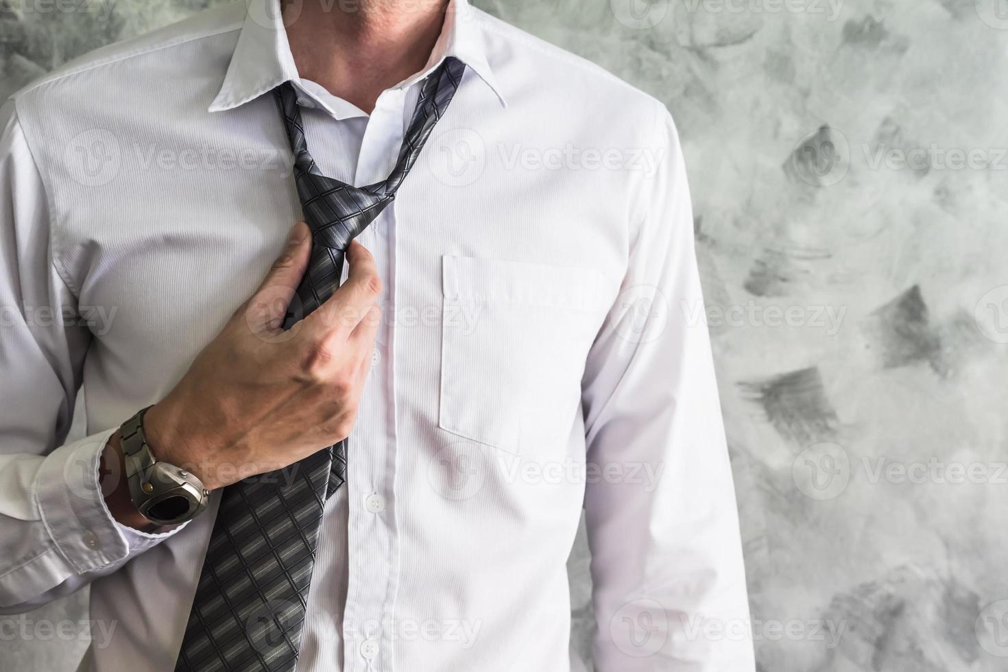 Close up of Man adjusting his necktie on grunge background. photo