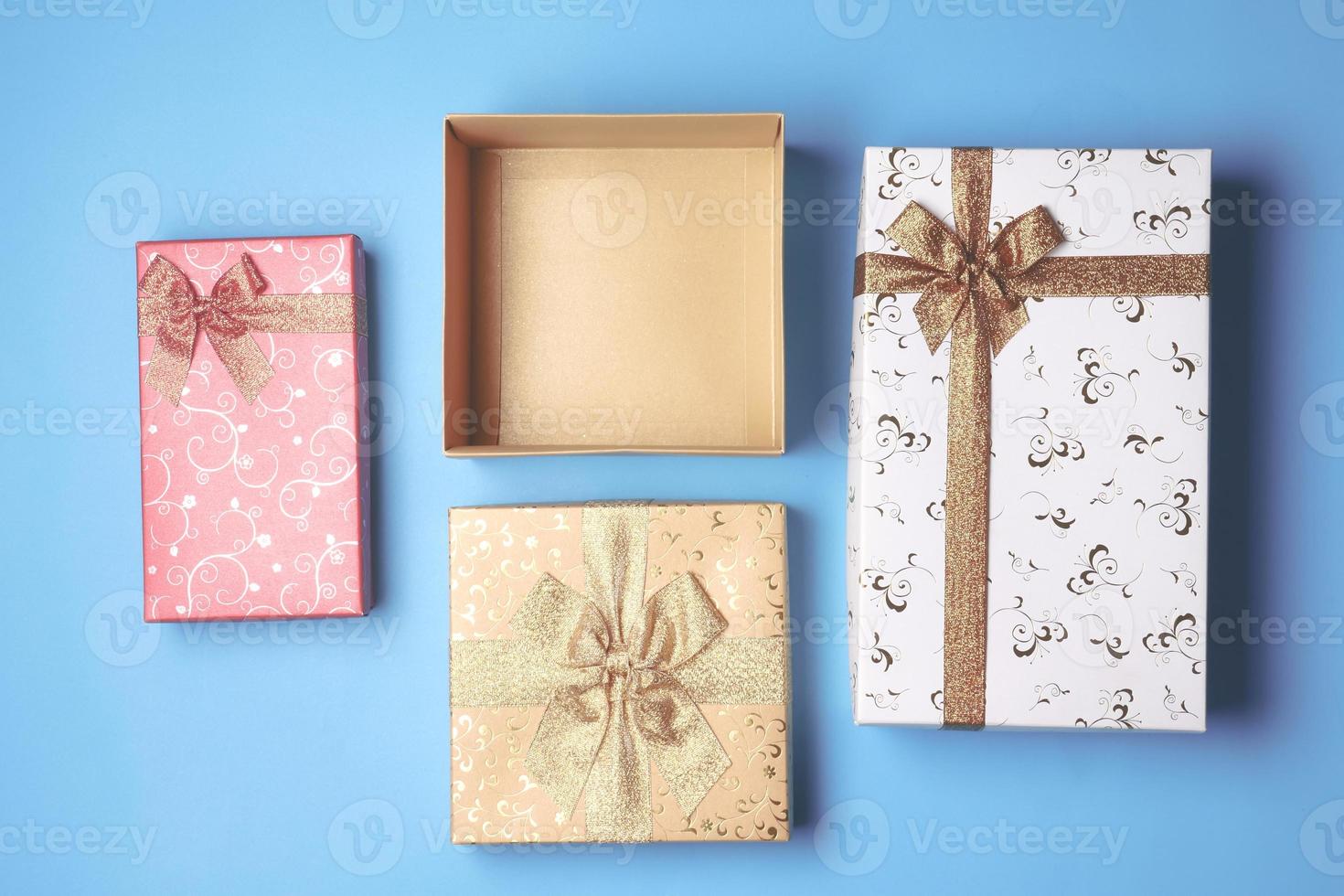 Top view of open gift box and presents on blue background. photo