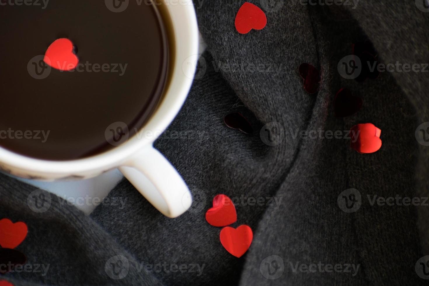 acogedora bufanda gris suave con una taza de café. Mañana. día de San Valentín foto