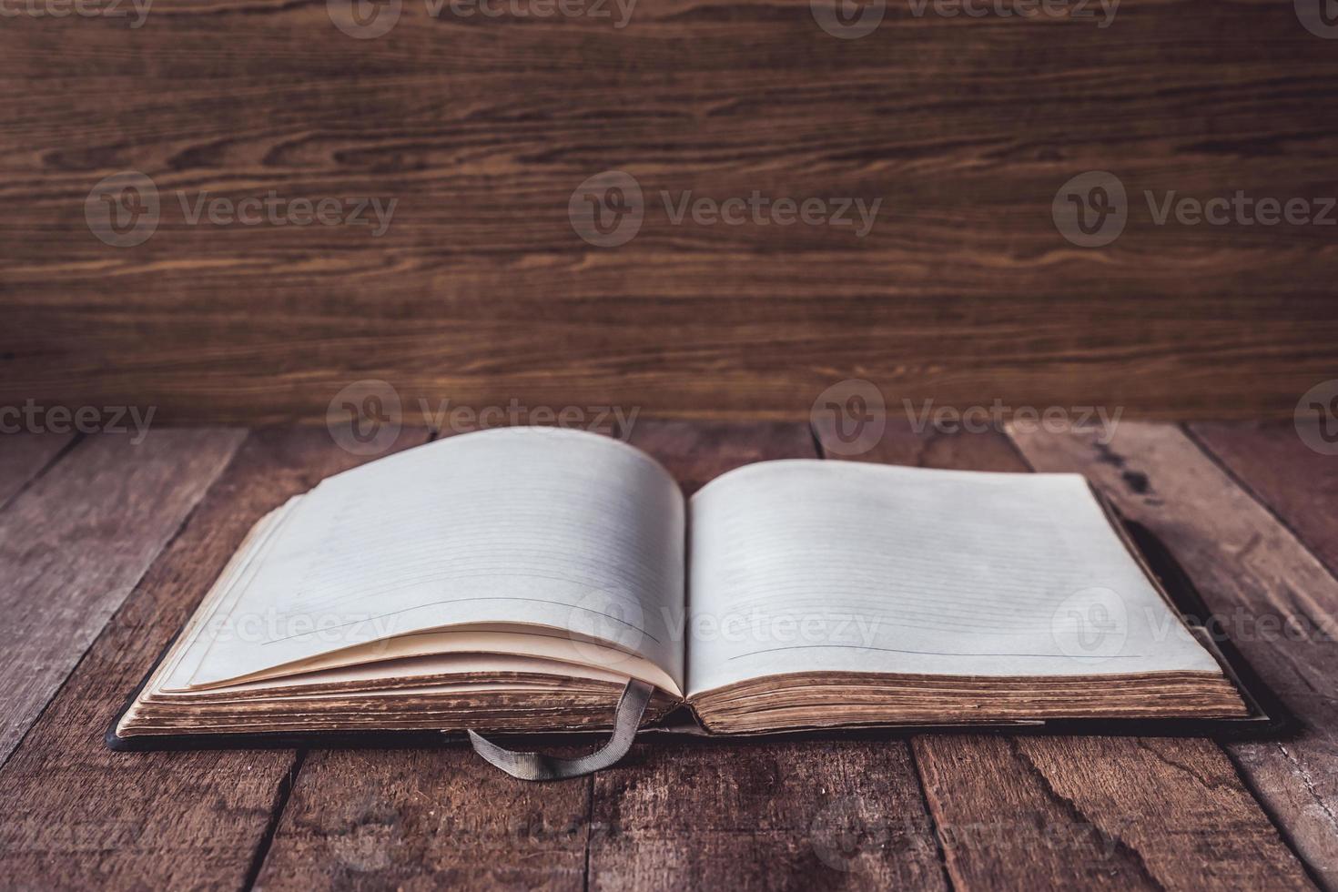 Blank old notebook on wooden table background. photo