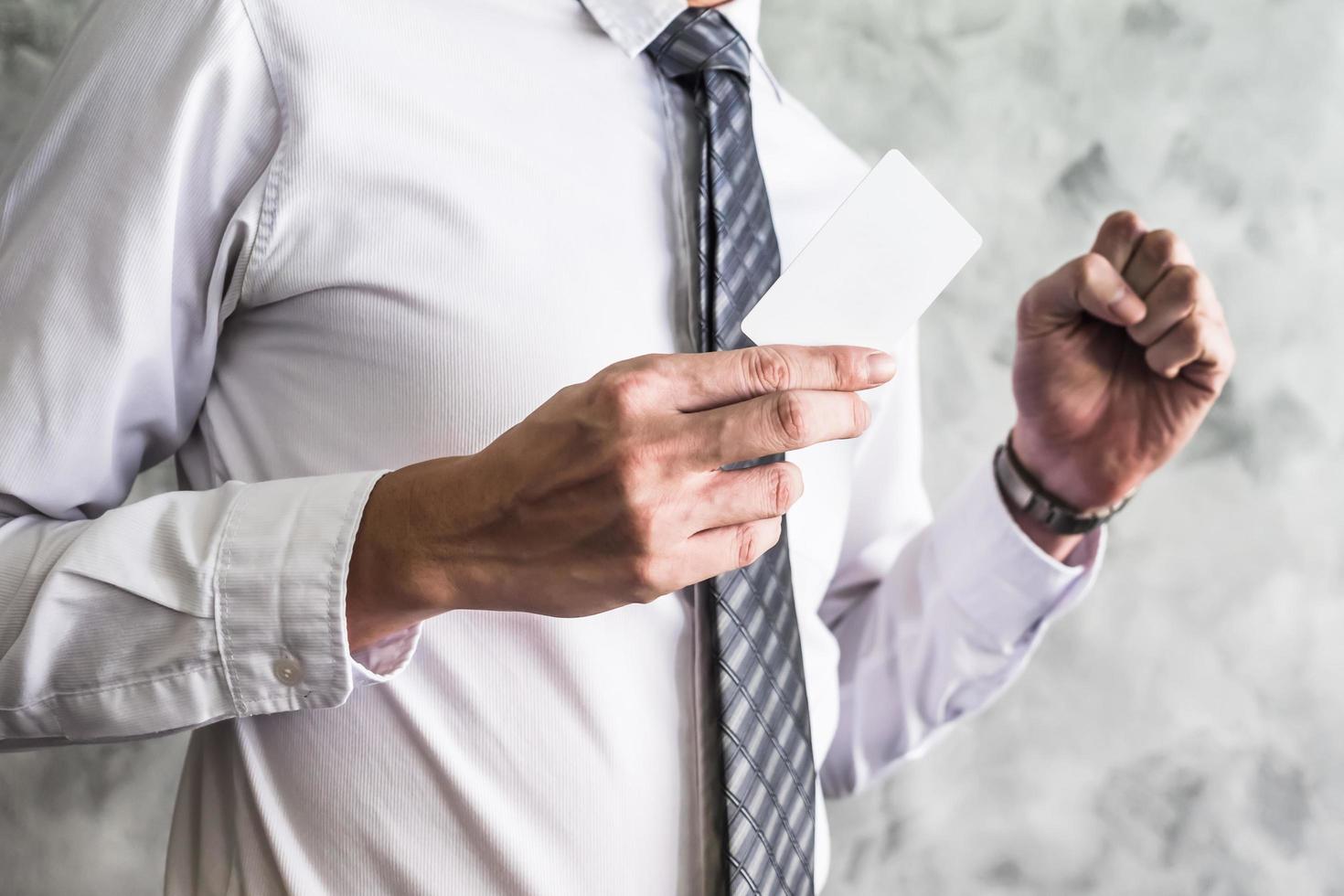 Close up of businessman holding white blank card on grunge background. photo