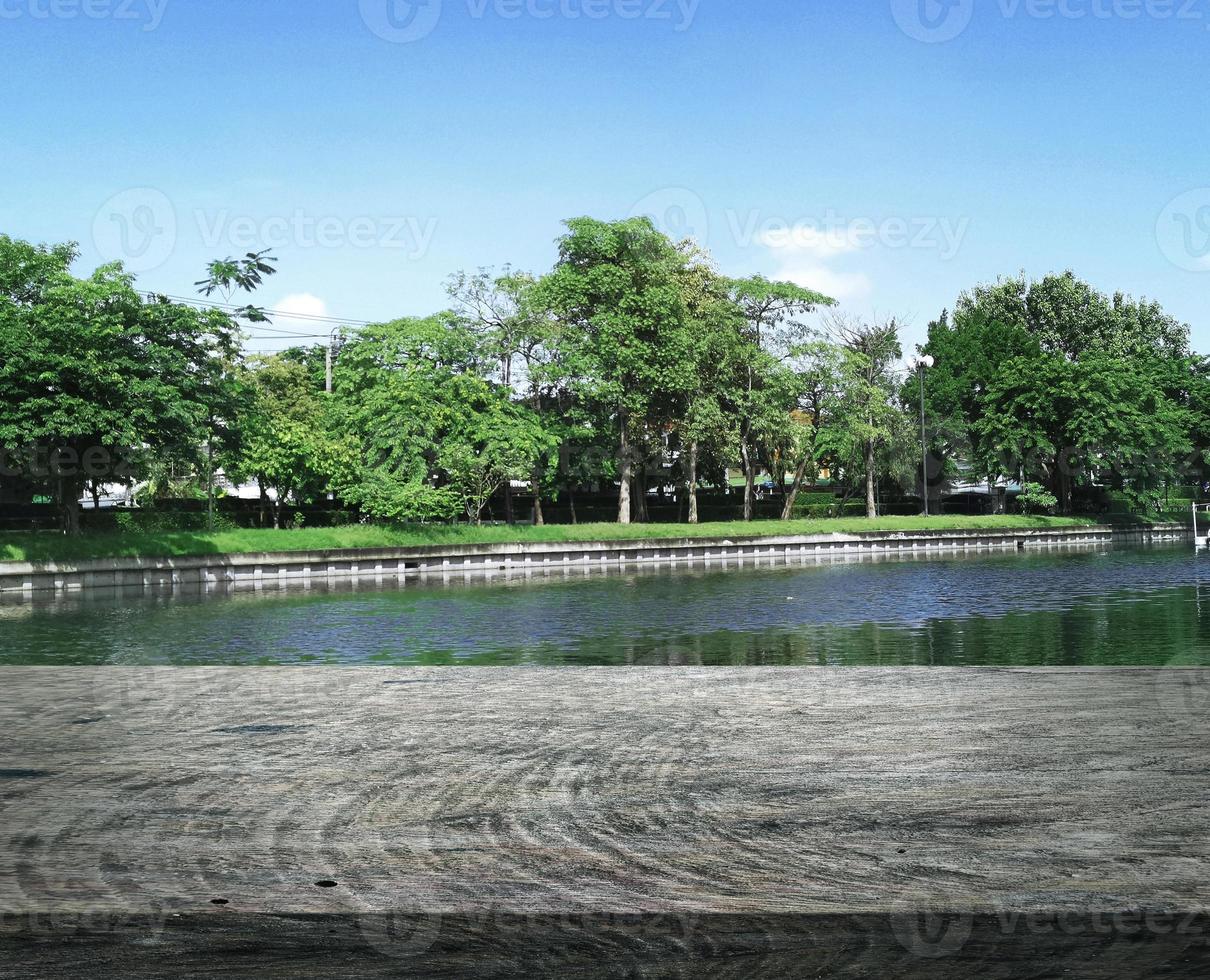 Wooden table terrace with a refreshing atmosphere in the morning, little swamp lake in summer photo