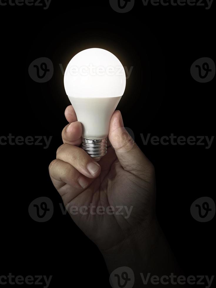 LED lamp in hand on black background photo