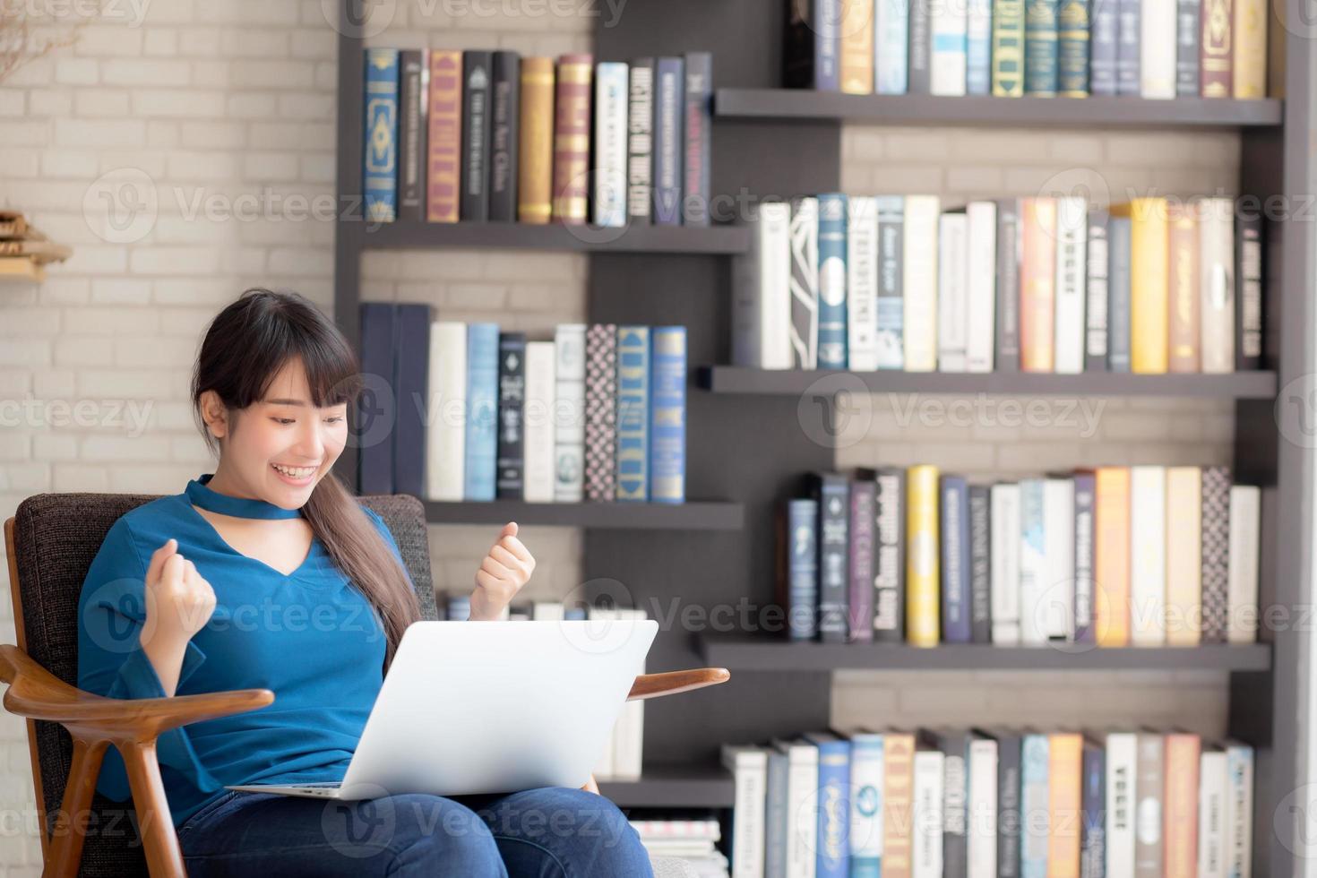 Beautiful of portrait happy young freelance asian woman using laptop work with success on chair in the home, asia girl and notebook shopping online with glad, communication concept. photo