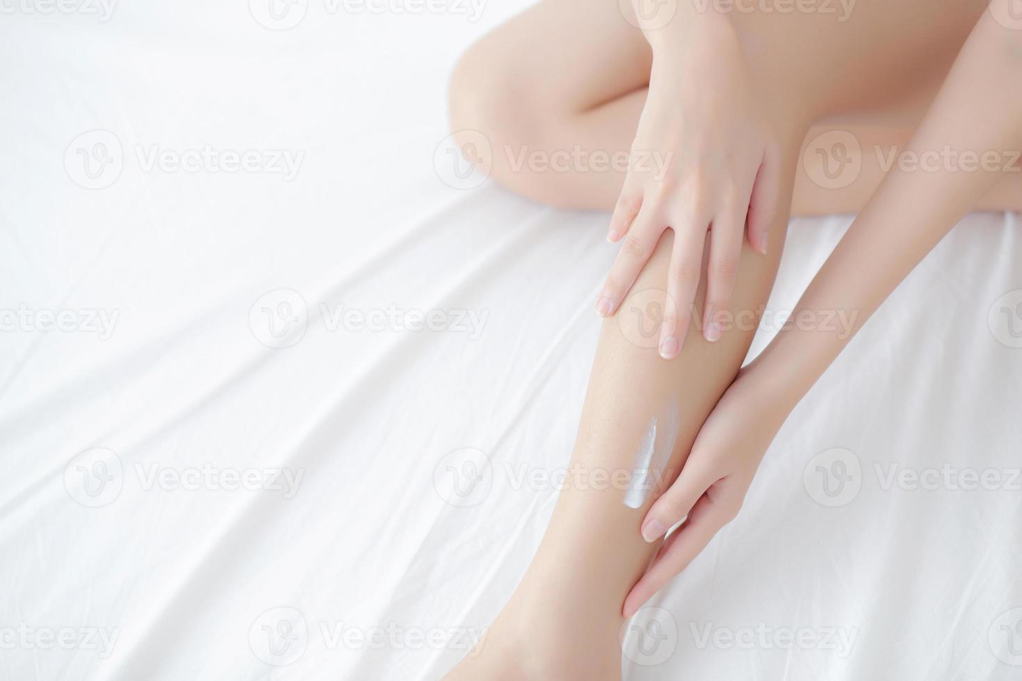 Young asian woman touch skin leg smooth with cream and lotion for hydration and smooth, girl applying body care and cosmetic for silky and soft, beauty perfect with wellness, health and care. photo