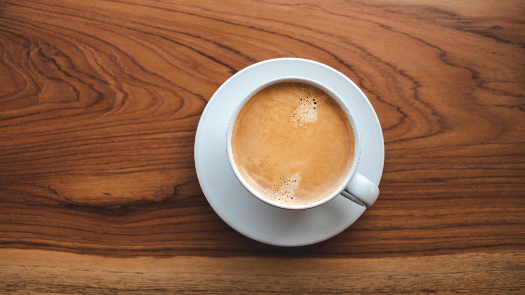 Top view of coffee cup with foam on wooden table.close-up photo