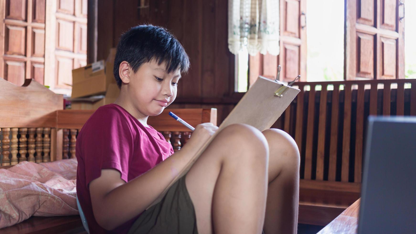 Asian boys enjoy free time practicing pencil drawing at home during school holidays. Kid Creators concept photo